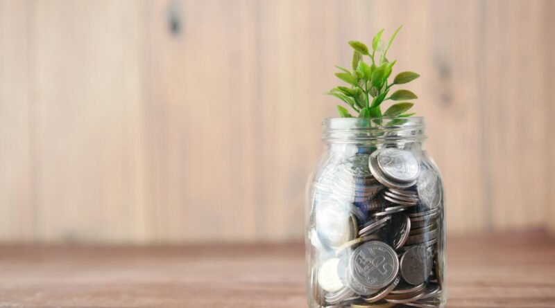 a glass jar filled with coins and a plant
